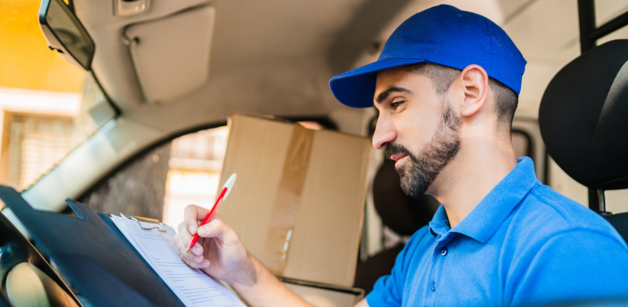 Delivery man checking a list inside his van