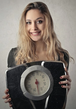 Girl holding a weighting scale