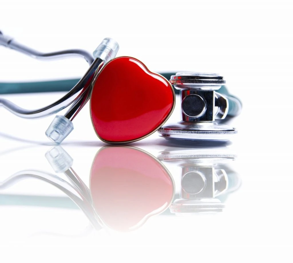A heart shaped pin beside a stethoscope
