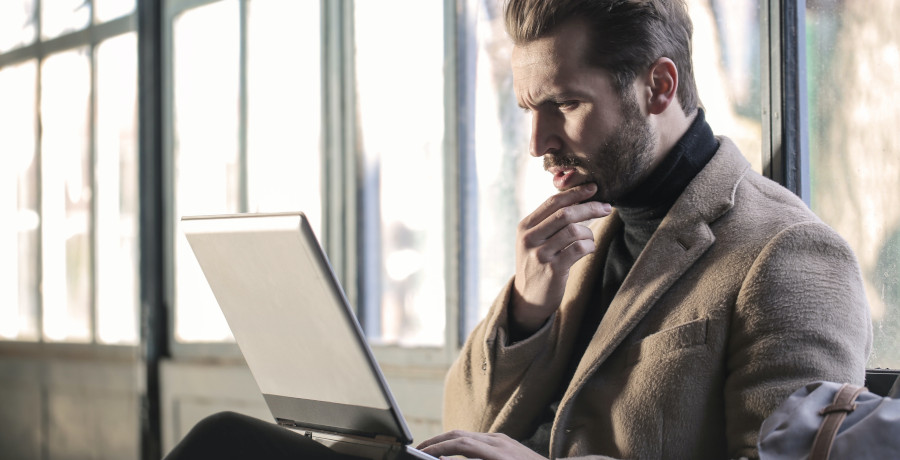 Man using laptop looking shocked