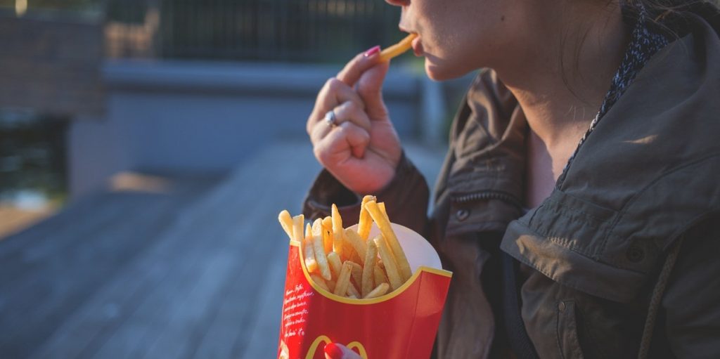 Woman eating fried potatoes