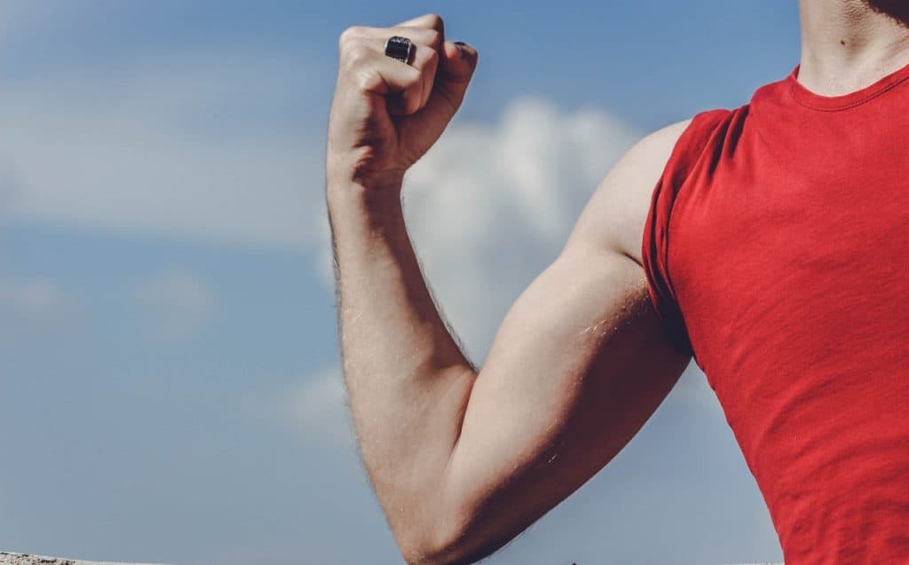 Muscled man raising arm