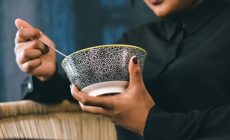 Person holding a bowl of Chinese food