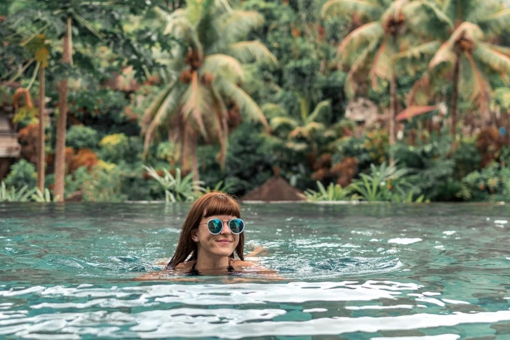 A woman swimming with sunglasses on