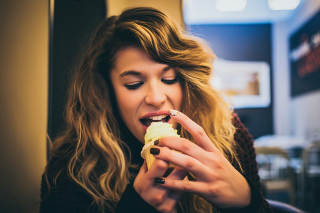 A woman eating cupcakes