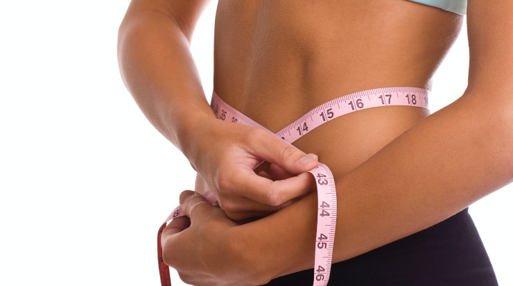 Slim woman using a measuring tape