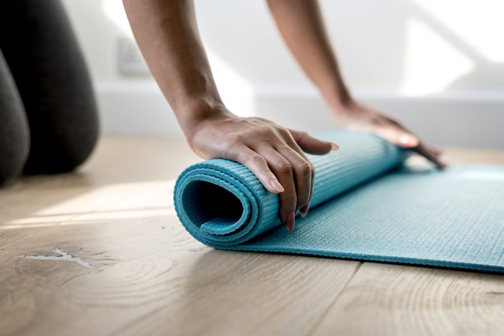 Woman rolling a yoga mat