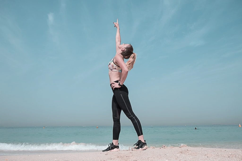 A fit woman pointing at the sky