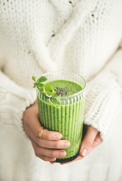 Woman holding a matcha green vegan shake